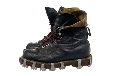 Tabanda metal çivili deri çizmeler, kahverengi bağcıklar ve kumaş kelepçeler..