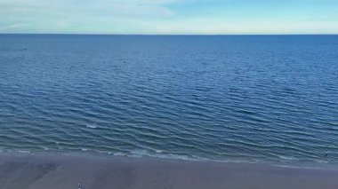 Tayland 'da berrak gökyüzü altında sakin bir deniz ve boş bir plaj. Yüksek kalite 4k görüntü