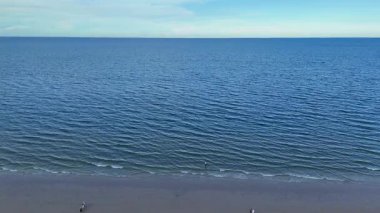 Kumlu sahilde kimsenin olmadığı huzurlu bir deniz manzarası. Yüksek kalite 4k görüntü