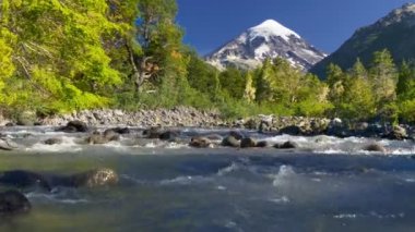 Volkan, dağ nehri ve yeşil ağaçlarla kaplı bir manzara. Lanin Ulusal Parkı 'ndaki Lanin volkanı. Arjantin, Patagonya, Göl Bölgesi