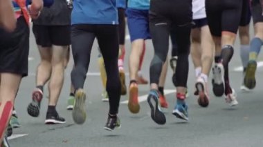 Sokaktaki Maraton koşucuları. Maraton koşu yarışı. Yavaş çekim yakın çekim koşucu bacakları