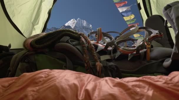 ネパールヒマラヤ山脈の旅行 登山の準備ができています カメラのテントの中では バックパック クランポン ブーツを移動します 仏教の旗が風になびく テントの中で眠る — ストック動画