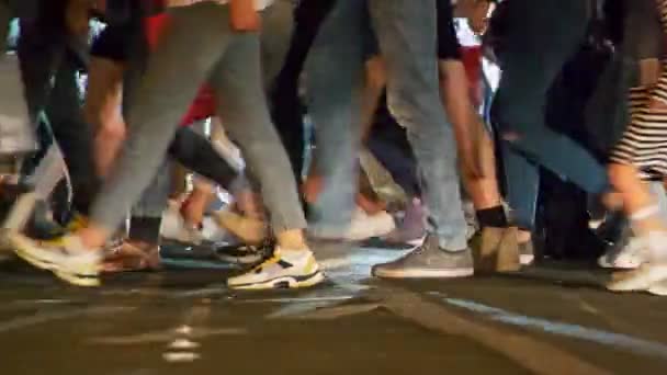 大都市でラッシュアワー 横断歩道の人々 認識できない人々は夜に横断歩道で道路を横断 車を停止し 彼らのライトをオンに待っている スローモーションショット — ストック動画