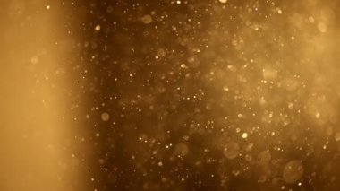 Shining golden particles abstract background. Gold dust particles fly in the air. Glimmering glowing gold bokeh background. Magical fairy background