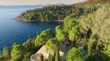 Sunrise on the coast of Corfu island, Greece. Aerial view of villas surrounded by green trees, park and lagoons with turquoise water. Corfu Island in summer is great place to relax at sea and travel 2