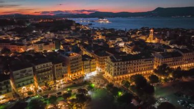 Evening aerial sunset view of Kerkyra, capital of Corfu island, Greece. Old town with illumination against background of red sunset sky in Kerkyra, Corfu island 2