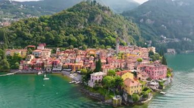 İtalya, Como Gölü 'ndeki Varenna köyünün renkli evleri üzerinde uçuyor. Yaz lüks turizmi. Romantik balayı gezisi merkezi. Como Gölü kıyısındaki eski Varenna kasabasını hava saldırısı vurdu.