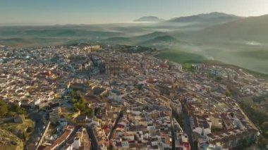 Jaen, Andalusia, Spain after sunrise with foggy green hills at background. Aerial view of Jaen Cathedral early in the morning. UHD, 4K 2