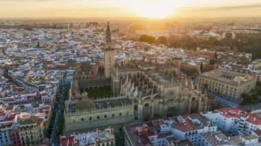 Aerial shot of Seville city center with gothic cathedral and famous Giralda bell tower. Gorgeous sunrise in Seville, Spain. UHD HDR