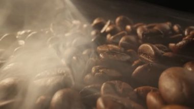 Arka planda sigara dumanı olan kahve çekirdekleri kızartıyorum. Duman taze kahve çekirdeklerinden gelir. Kızarma sırasında kahve çekirdekleri kaymış. UHD, 4K