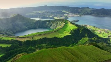 Güneşli bir günde Lagoa das Sete Cidades gölünün üzerinde uçmak. Sao Miguel Adası, Azores, Portekiz. Yeşil bitki örtüsüyle çevrili sönmüş volkanların kraterlerinde göller.