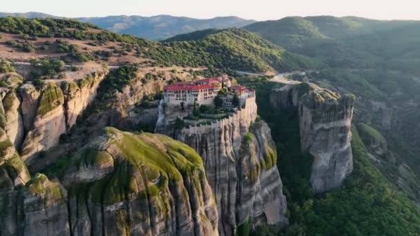 ギリシャの日の出にメテオラ修道院を飛んでいます 緑の丘 古い修道院と風景の風景です 空中写真4K — ストック動画