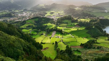 Güneşli bir günde Lagoa das Sete Cidades gölünün üzerinde uçmak. Sao Miguel Adası, Azores, Portekiz. Yeşil bitki örtüsüyle çevrili sönmüş volkanların kraterlerinde göller.