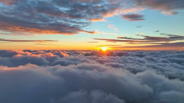 史诗般的夕阳笼罩着云彩 日落时在天空中飞行 从飞机的窗户看去 温暖的太阳升上地平线 笼罩在云彩中 — 图库照片