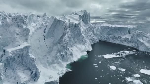 グリーンランドのイルリサット近くの巨大な氷山の近くで飛んでいる 海で雪に覆われた氷山の巨大なブロック 地球温暖化と気候変動のコンセプト — ストック動画