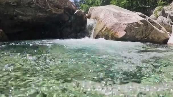 水晶般清澈的山溪半水下慢镜头 河水在形成小瀑布和浴池的石头之间流动 — 图库视频影像