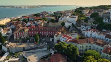 Lizbon 'un en eski mahallesi olan Alfama' daki evler ve sokaklar Tejo nehrine bakıyor. Lizbon 'daki Alfama bölgesinin hava manzarası, turistler şehrin eski caddelerinde yürüyor