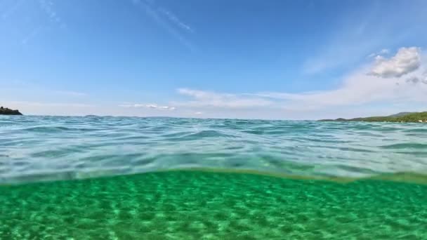 半水下慢镜头的沙滩底部 蓝天和云彩 希腊Halkidiki市Sitonia的水晶清澈海水 从空气和水的边界用穹顶射击 — 图库视频影像