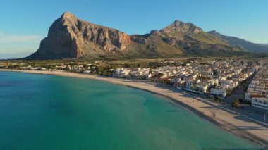 San Vito Lo Capo 'nun hava görüntüsü - Sicilya, İtalya' daki plaj ve kasaba. San Vito Lo Capo 'daki dağın eteğinde turkuaz su bulunan sahil - Batı Sicilya' nın turistik incisi.
