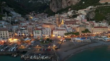 Amalfi kasabasının şehir ışıklarıyla çekilmiş akşam fotoğrafları. İtalya 'nın Campagna kentindeki ünlü Amalfi sahili. 4K, UHD