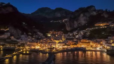 Amalfi kasabasının şehir ışıklarıyla çekilmiş akşam fotoğrafları. İtalya 'nın Campagna kentindeki ünlü Amalfi sahili. 4K, UHD
