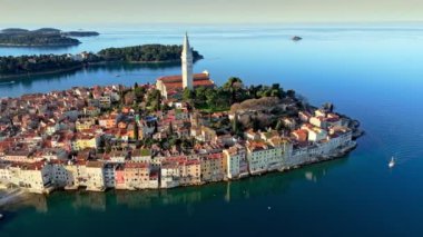 Eski Rovinj kasabasında renkli evler ve Aziz Euphemia Kilisesi. Güneş doğarken Rovinj, Hırvatistan 'ın Istrian yarımadası. Hava atışı, 4K