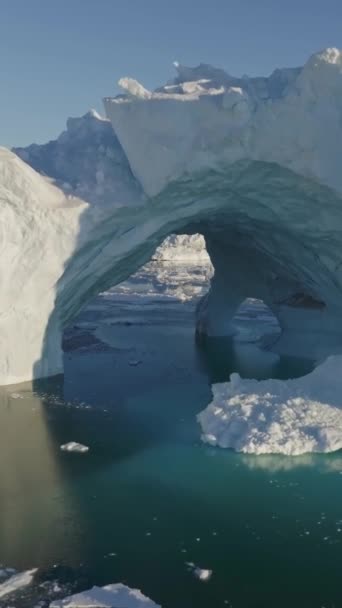 グリーンランドのイルリサット近くの巨大な分割氷山の近くで飛行 海で雪に覆われた氷山の巨大なブロック 航空宇宙の自然景観 地球温暖化 気候変動の概念 縦スクリーン — ストック動画