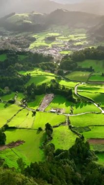 Sao Miguel Adası, Azores, Portekiz 'deki yeşil çayırlar, dağlar ve Furnas şehrinin havadan görüntüsü. Güneşli bir günde Azores Doğa. Dikey ekran 