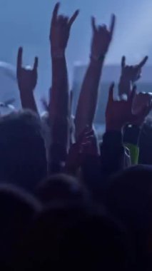 Rock konserindeki hayranlar. Sahne ışıklarında el çırpan insanlar. Bir konser ya da festival partisinde dans eden tanınmamış hayranlar. Konser kalabalığının siluetleri, Dikey Ekran