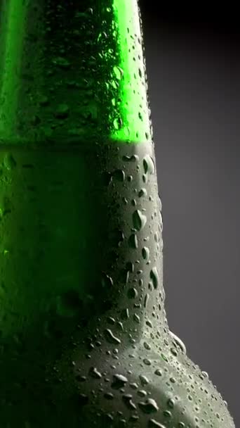凝縮した冷たいビールのクラシックグリーンボトル 回転によるチルトショット バーティカルショット — ストック動画