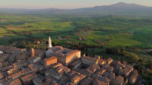 ピンツァの古い町を飛んで 背景にあるトスカーナの緑の丘 ペンツァーリャ中世の村 トスカーナ イタリアの空中サンセットビュー — ストック動画