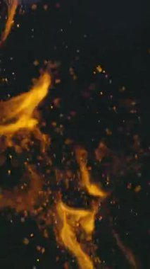 Kıvılcımlı ve bokeh daireli alevler. Geceleyin gerçek şenlik ateşinin soyut arka planı. Işık ve sıcaklık kavramı. Büyük ateşten yükselen kıvılcımlar. Dikey video