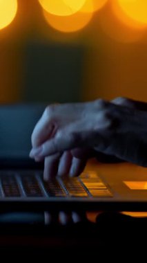 Geceleri laptopta masaj mesajı yazmak. Karanlık odada çalışan bir kadın. Dikey çekim