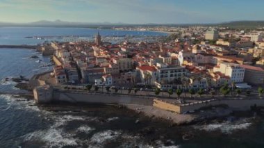 Alghero 'nun eski kasabası, Sardinya, İtalya' da uçuyoruz. Antik İtalyan şehri ve limanının günbatımında havadan çekilmiş görüntüleri.