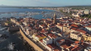 Alghero 'nun eski kasaba ve limanı, Sardinya, İtalya' nın altın saat görüntüsü. Gün batımında Alghero 'daki San Francesco Kilisesi ve eski İtalyan şehri Sardegna.