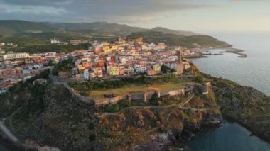 Deniz kenarındaki muhteşem Castelsardo kasabası. Gün batımında şehir duvarlarının, renkli evlerin ve kalenin havadan görünüşü, İtalya 'nın Sardunya adasında Castelsardo