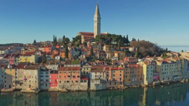 Güneş doğarken Rovinj, Hırvatistan 'ın Istrian yarımadası. Eski Rovinj kasabasında renkli evler ve Aziz Euphemia Kilisesi. Hava atışı, 4K