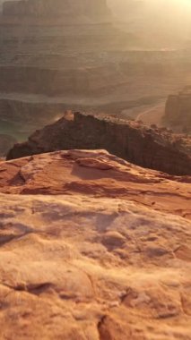 Dead Horse Point Eyalet Parkı, Utah, ABD. Gün batımında kırmızı kayalar görülür. Dikey sabit çekim