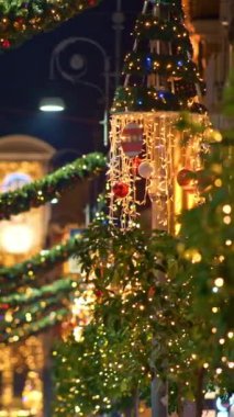 Noel ağacı süsleme ışığı ve yılbaşı ve yeni yıl tatilleri boyunca şehirde Noel sokak aydınlatması. Arkaplan mavisi. Sorrento, İtalya. Dikey Video 