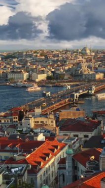 İstanbul, Türkiye. Galata Kulesi 'nden İstanbul şehir merkezinin gün batımı manzarası. Feribotlar Galata Köprüsü yakınlarındaki Golden Horn Körfezi boyunca yelken açarlar. Dikey Video 