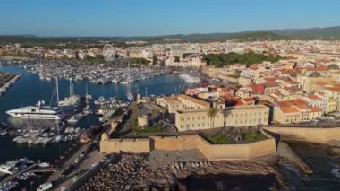 Alghero 'nun eski kasabası, Sardinya, İtalya' da uçuyoruz. Antik İtalyan şehri ve limanının günbatımında havadan çekilmiş görüntüleri. Sardunya - popüler turizm merkezi