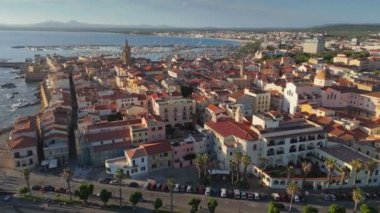 Alghero 'nun eski kasaba ve limanı, Sardinya, İtalya' nın altın saat görüntüsü. Gün batımında Alghero 'daki San Francesco Kilisesi ve eski İtalyan şehri Sardegna.