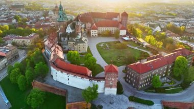 Polonya, Krakow 'daki Wawel Kalesi' nin nefes kesici manzarası. Kale, ortasında asfaltlı bir avlu olan yemyeşil bir alanla çevrilidir. Wawel Şatosu 'nun üzerinden ılık gün doğumu ışığında uç 