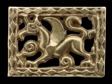 Avar döneminden kalma karmaşık altın kaplama kemer montu, dikdörtgen bir çerçevede mitolojik bir griffinin yer aldığı. Tarihi sanat ve zengin metalik dokuyu sergiler.