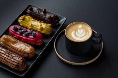 Çörek ve kahve. Siyah bir masanın üzerinde. Üst görünüm düz yüzey ve yüksek kaliteli fotoğraf kopyalamak için bir yer
