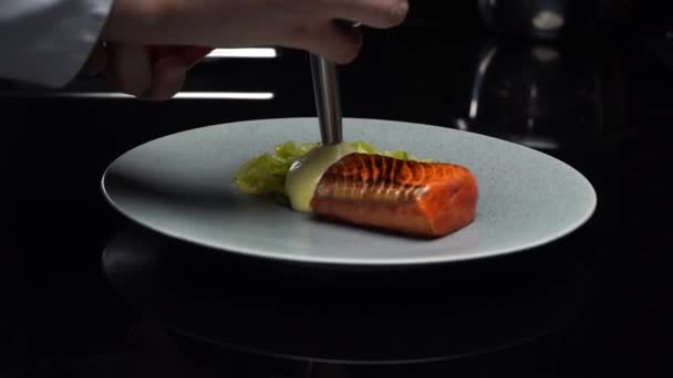 鮭魚ステーキ付きの料理 鮭の魚の上にソースをかけます 健康食品 メインコースはクローズアップです 高品質のフルHd映像 — ストック動画