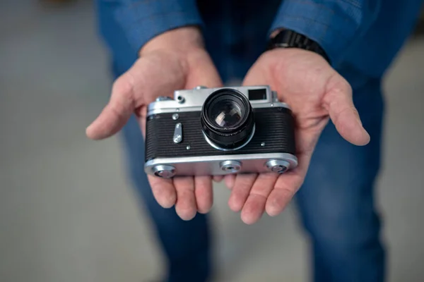 Male hands holding a vintage old camera . High quality photo