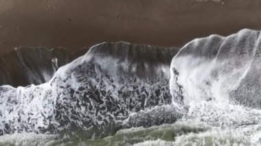 Koyu deniz dalgalarının güzel dokusu, beyaz bir renkle yüksek güçte. Fırtınalı bir günde deniz dalgalarının kuş bakışı görüntüsü. Okhotsk Denizi 'nde sörf. Sakhalinsk dalgaları. Ağır çekim. Yüksek