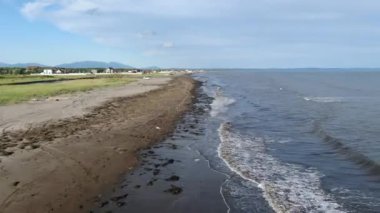 Okhotsk Denizi 'nin köpüklü dalgaları üzerinde uçarken Sakhalin Adası yakınlarındaki kumlu bir plaja doğru koşuyor. Yüksek kaliteli FullHD görüntüler