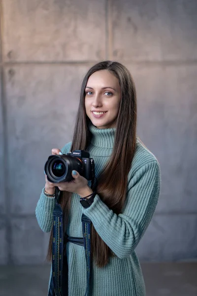 Красива Дівчина Сучасною Камерою Руках Зеленому Платті Дивлячись Камеру Посміхаючись — стокове фото